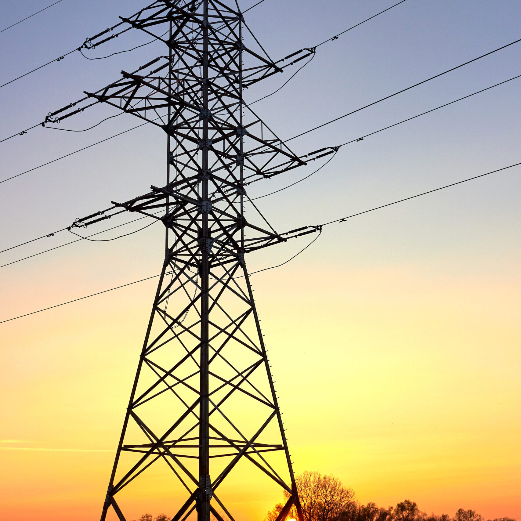 Silhouette Of Pylon And High Voltage Power Lines Against A Colorful Sky At Sunrise Or Sunset - electricity generated by renewable natural gas from anaerobic digestion